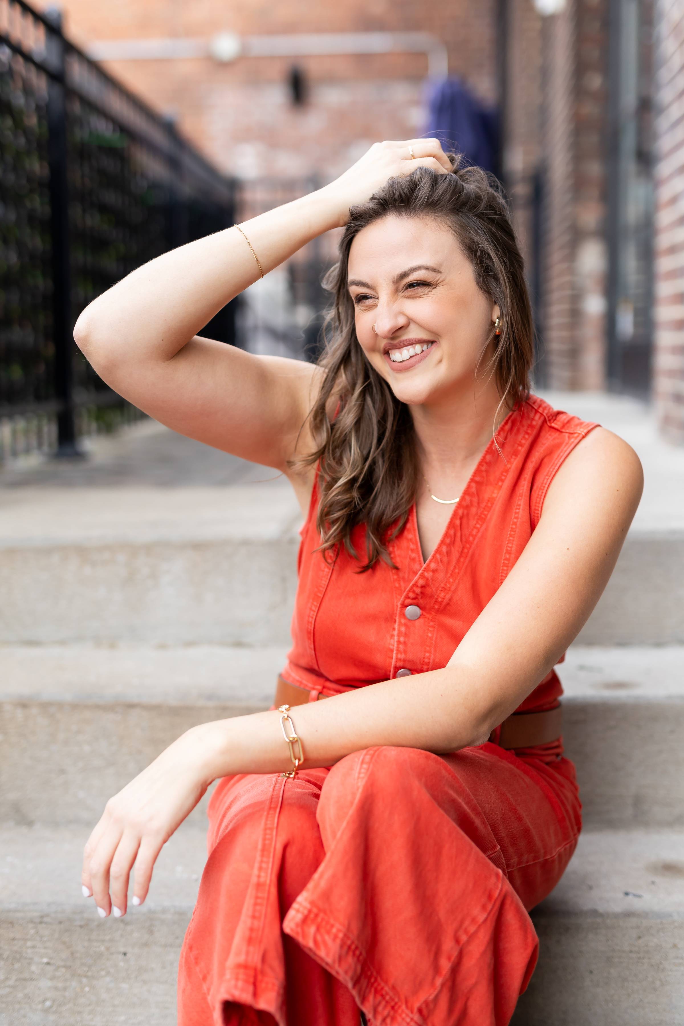 Image of Allea from her new brand photoshoot wearing a orange/red jumper
