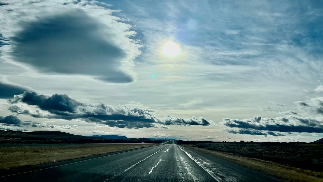 I 15 South in Montana, no traffic, only mountains and clouds.