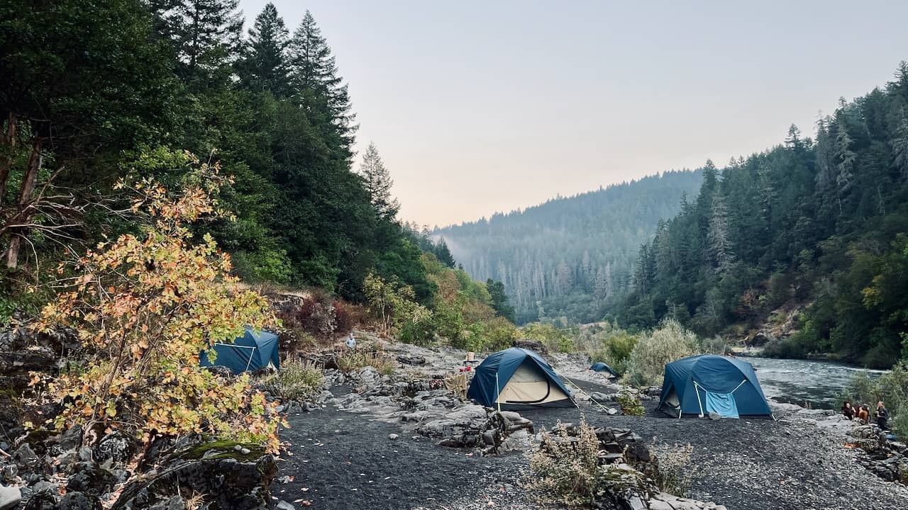 three tents on a pebbly beach along the Rogue River