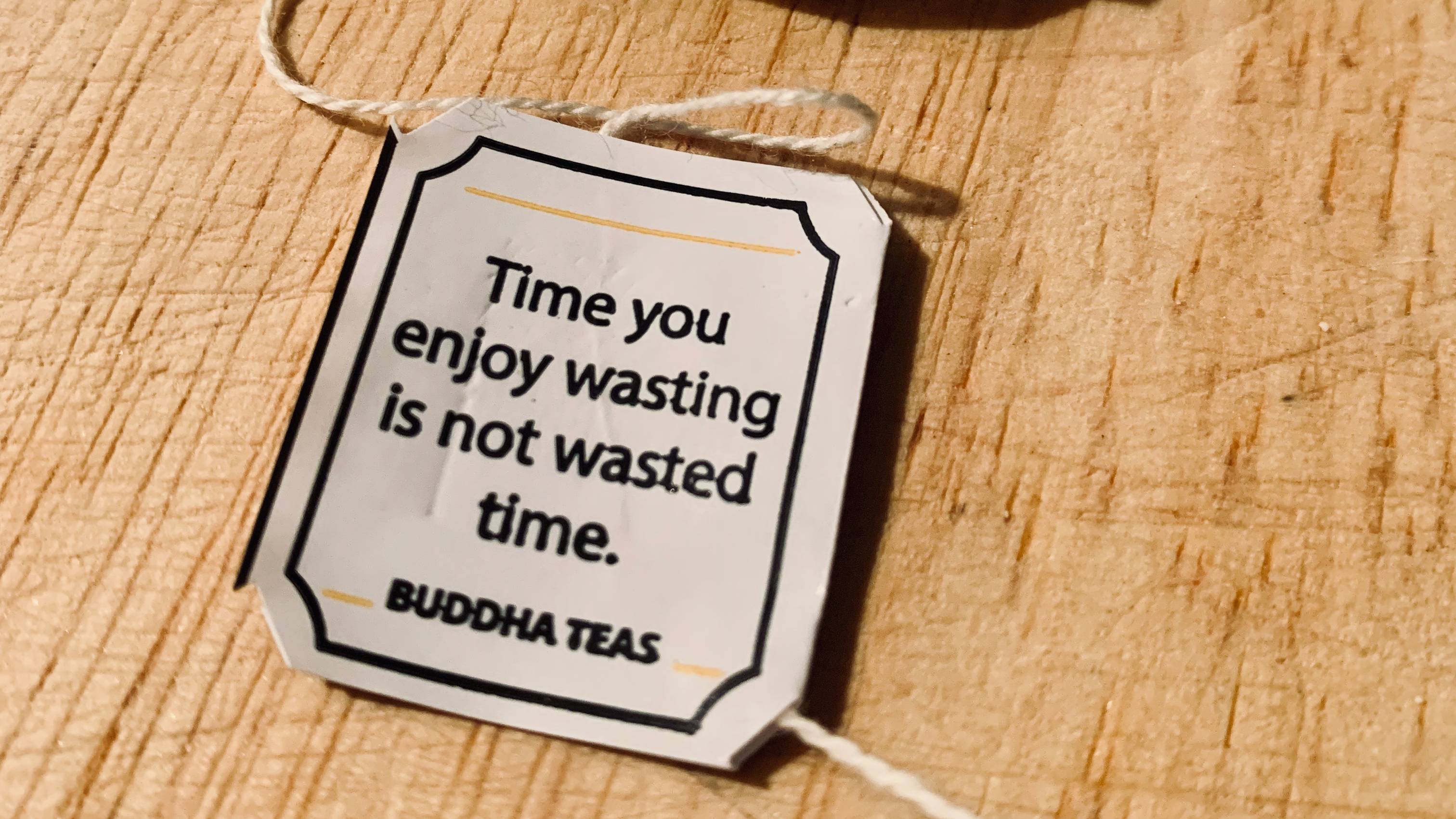 A tea bag tag reads Time you enjoy wasting is not wasted time.