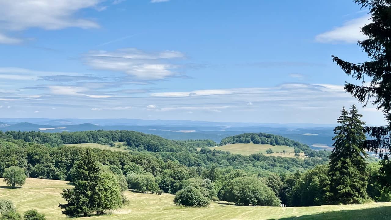 view over forests and fields with forested hills in the far distance