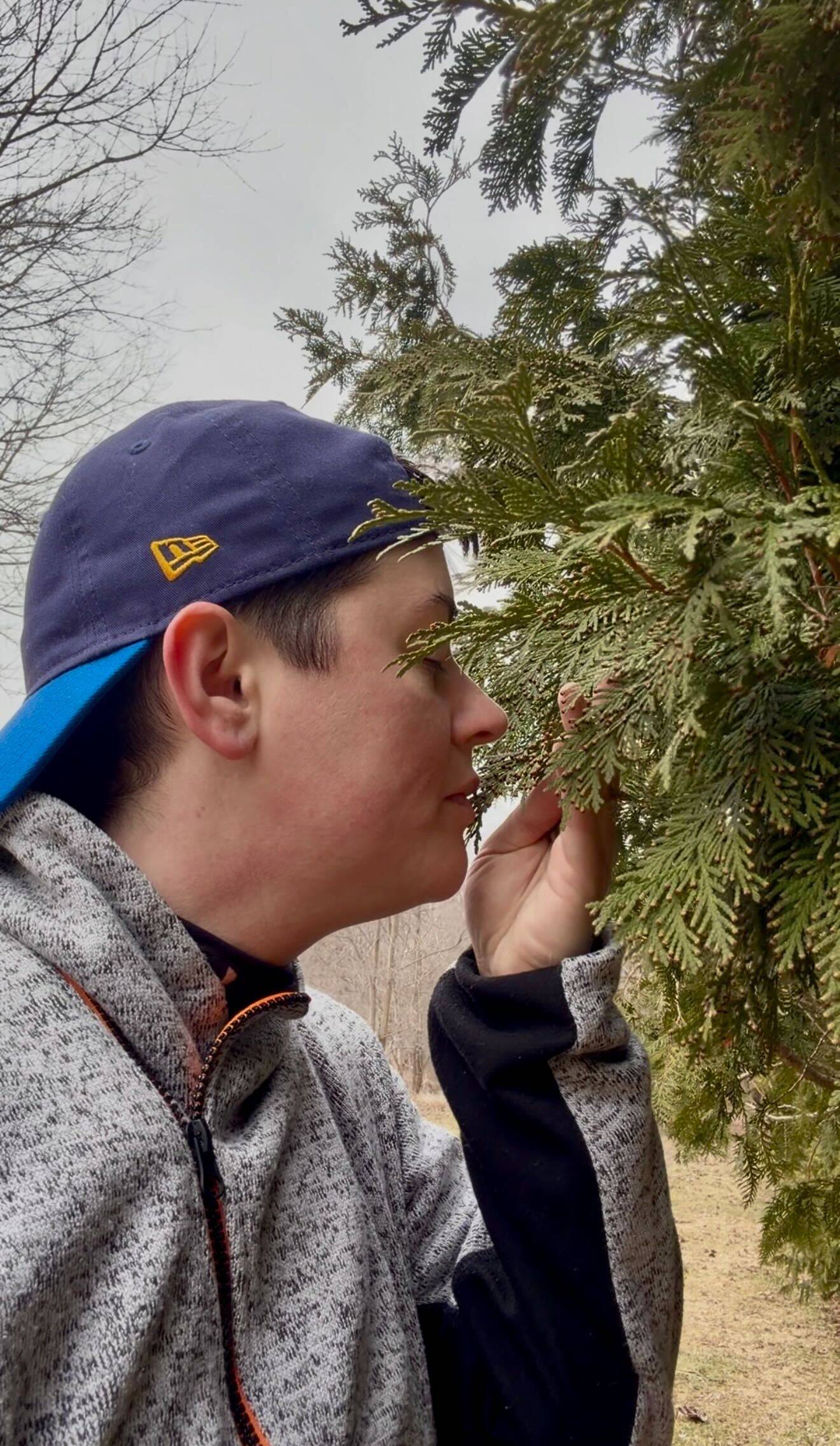 Frankie Edwards smells a cedar tree on their April Walk Series