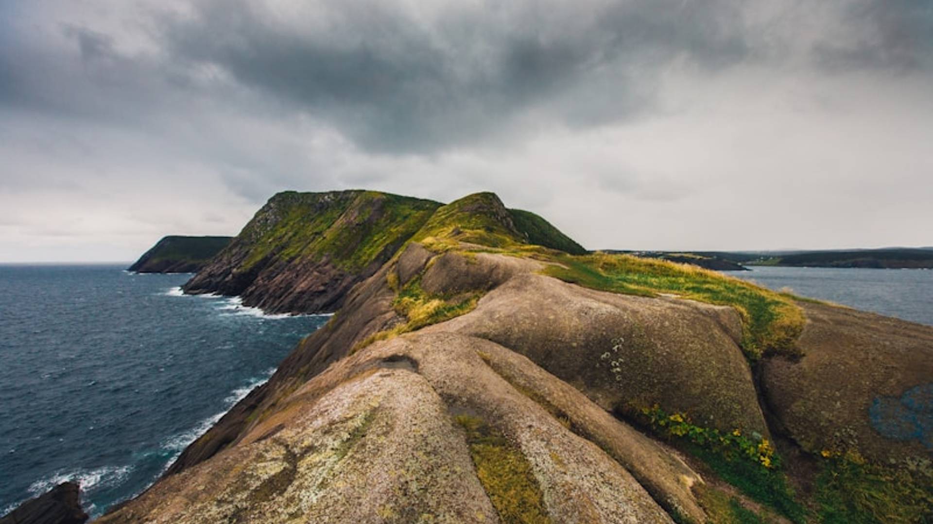 a rocky cliff next to the ocean