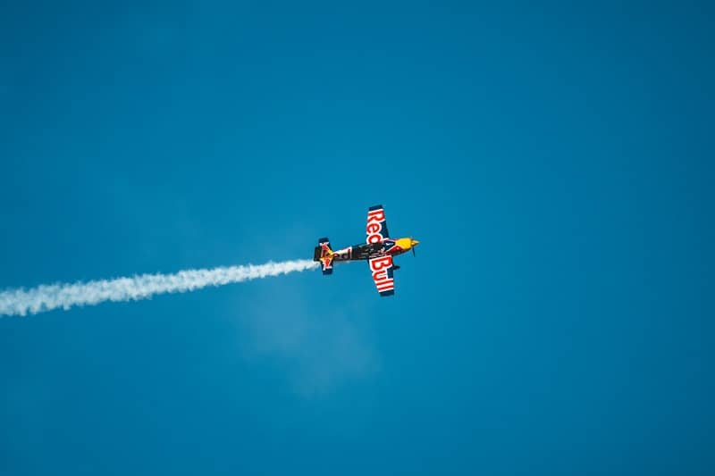 A small plane flying through a blue sky