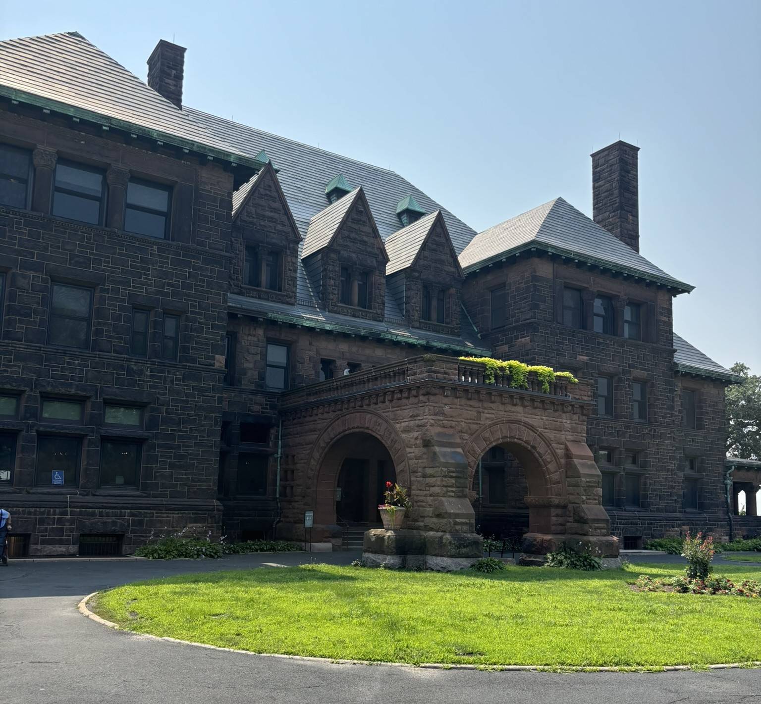 A dark red stone mansion with many gables