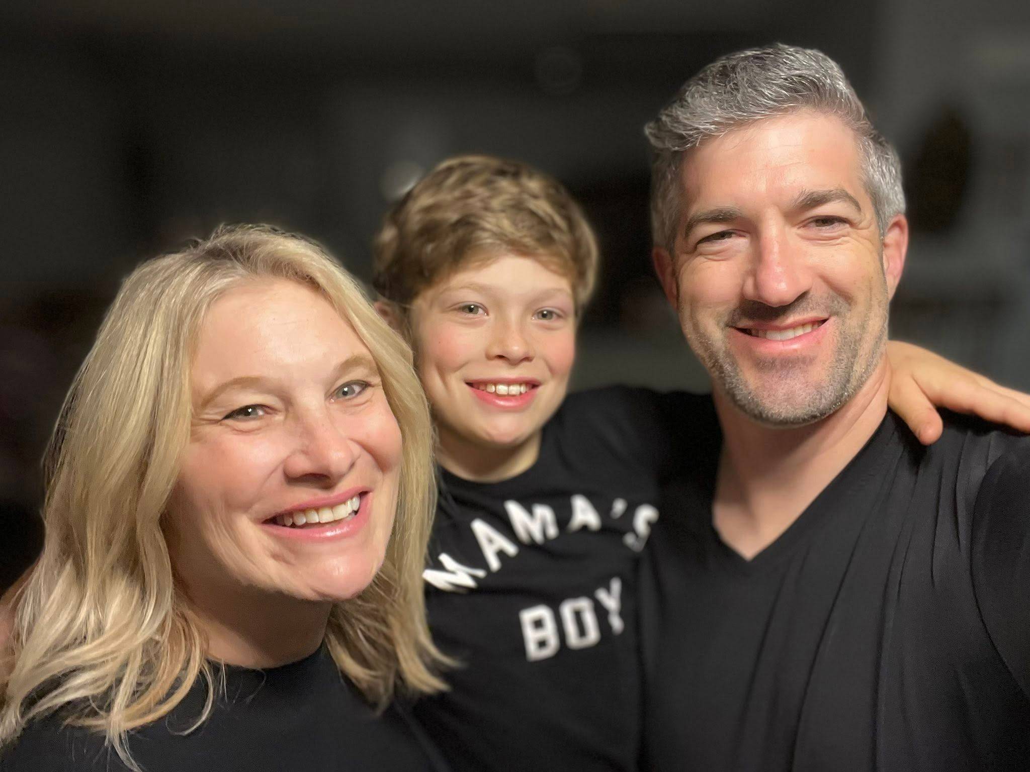 a blond woman with a blond boy and graying man, all wearing black