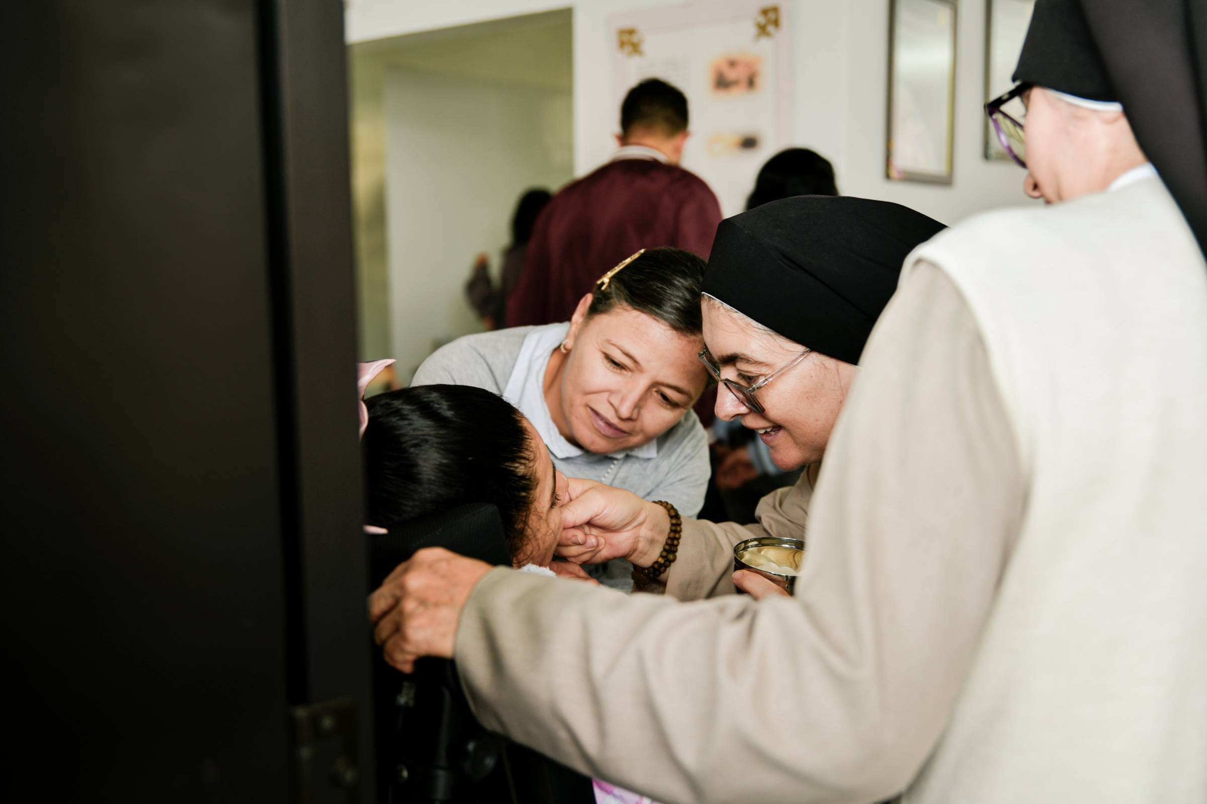 Nuns and a young girl attend to a child
