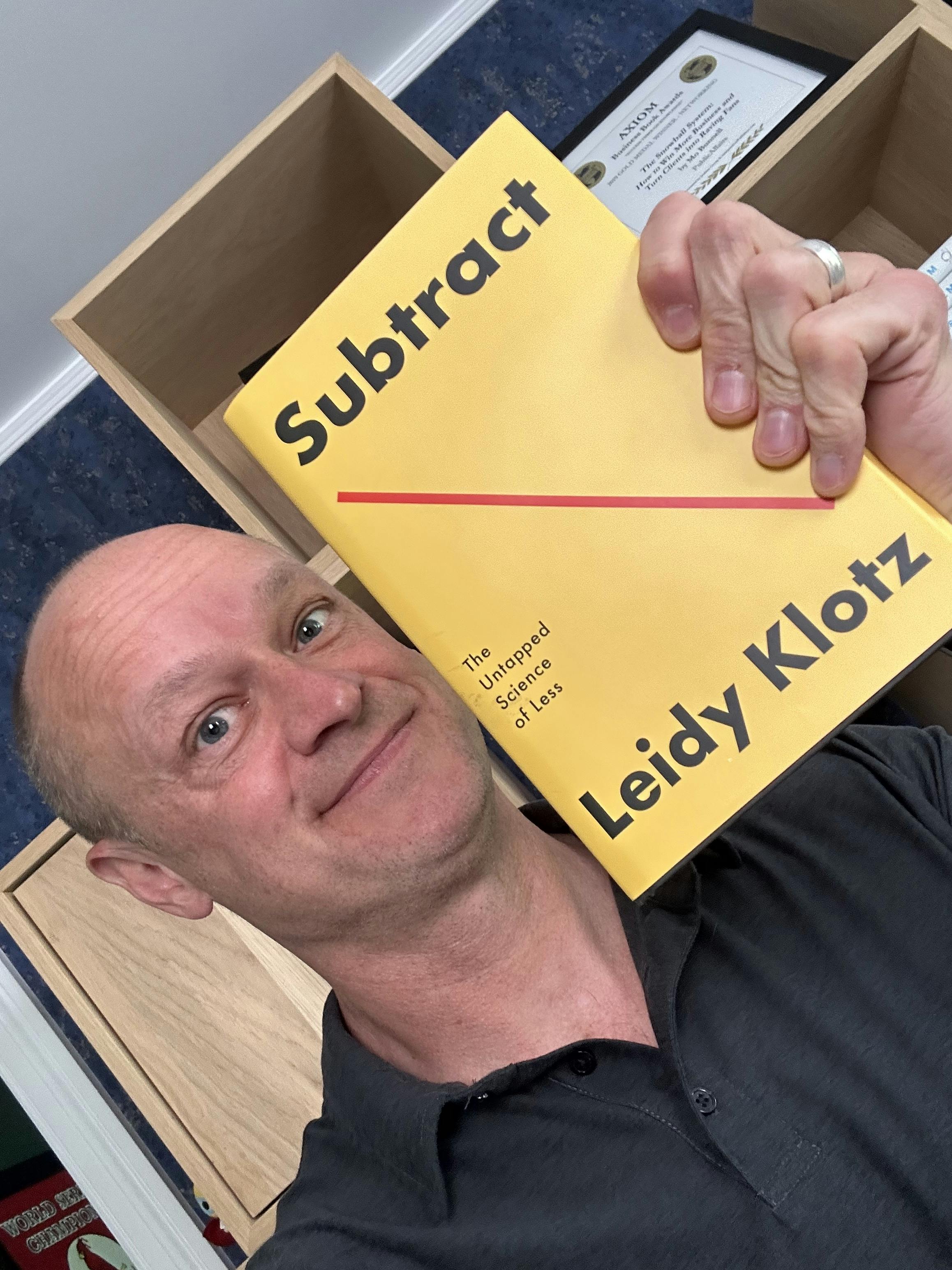 Mo Bunnell posing with Leidy Klotz's book Subtract