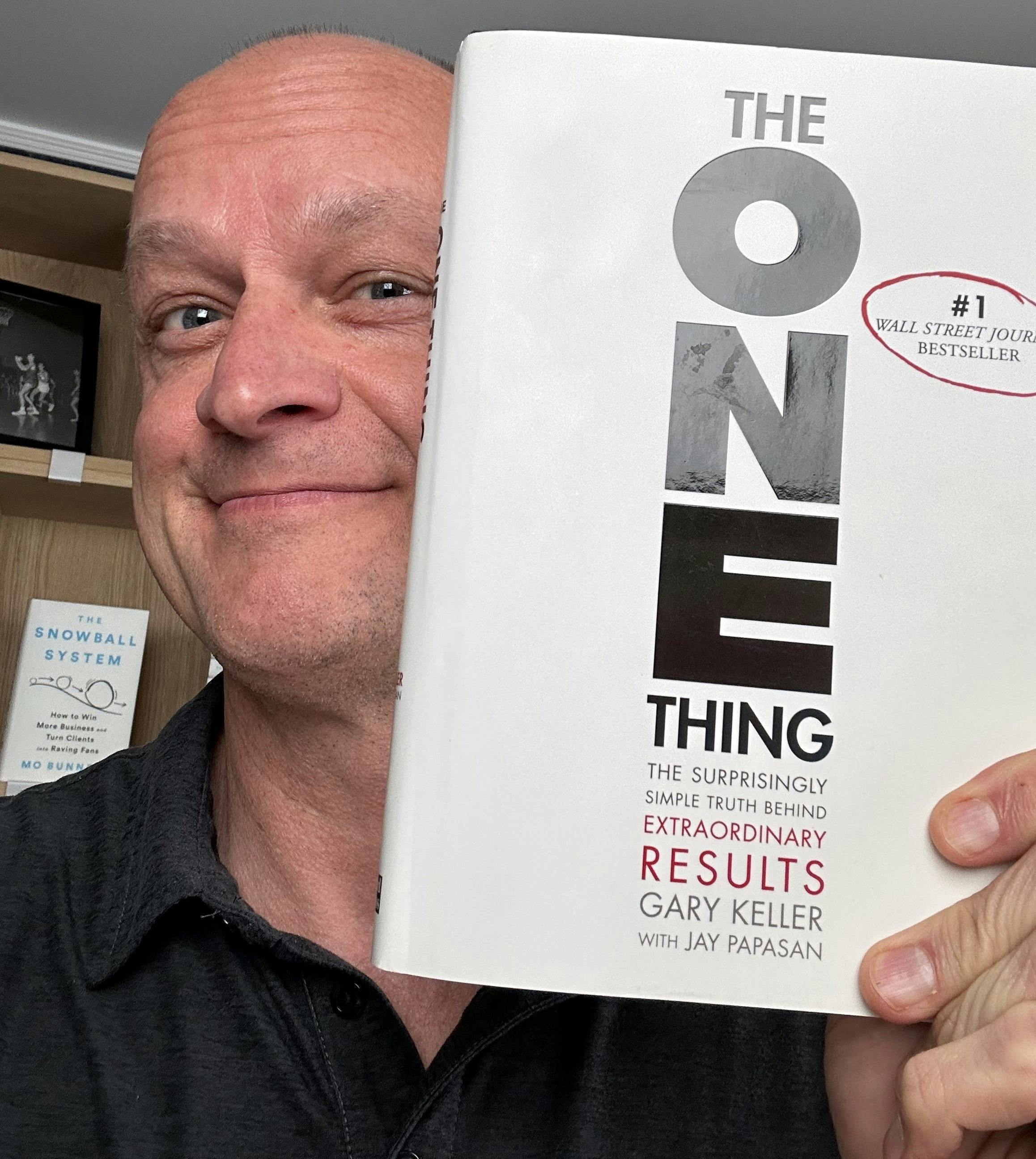 Picture of Mo holding coauthor Jay Papasan's book The One Thing