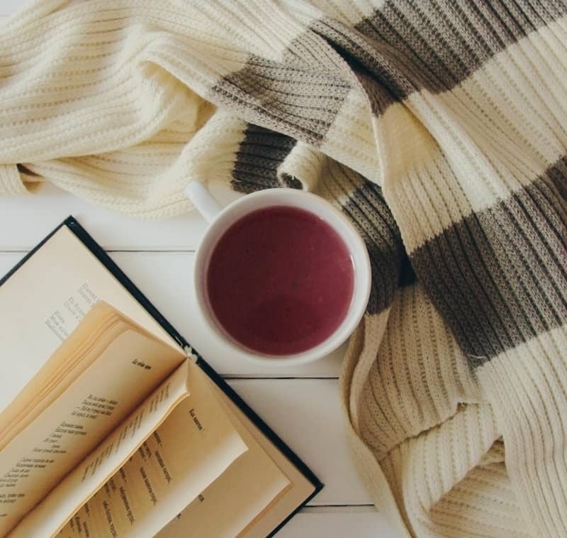 A cozy scene with a book and warm drink.