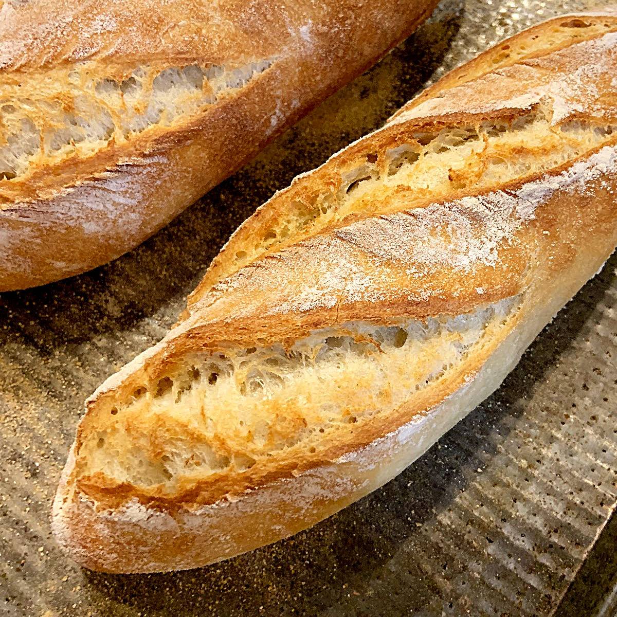 French baguettes on a metal baking sheet.