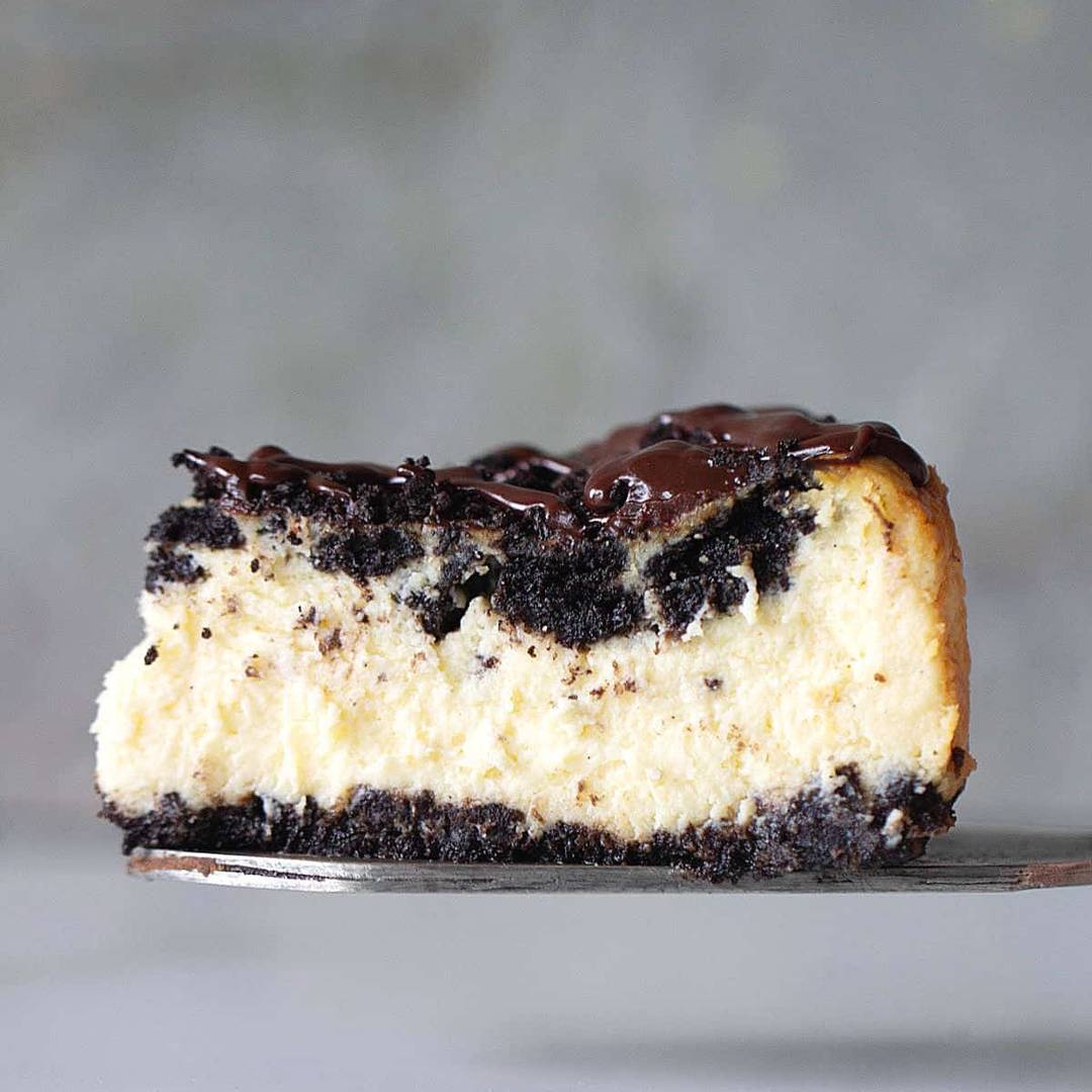 Slice of Oreo cheesecake on a gray background. 