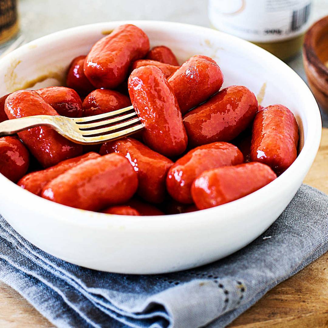 White bowl of cocktail sausages.