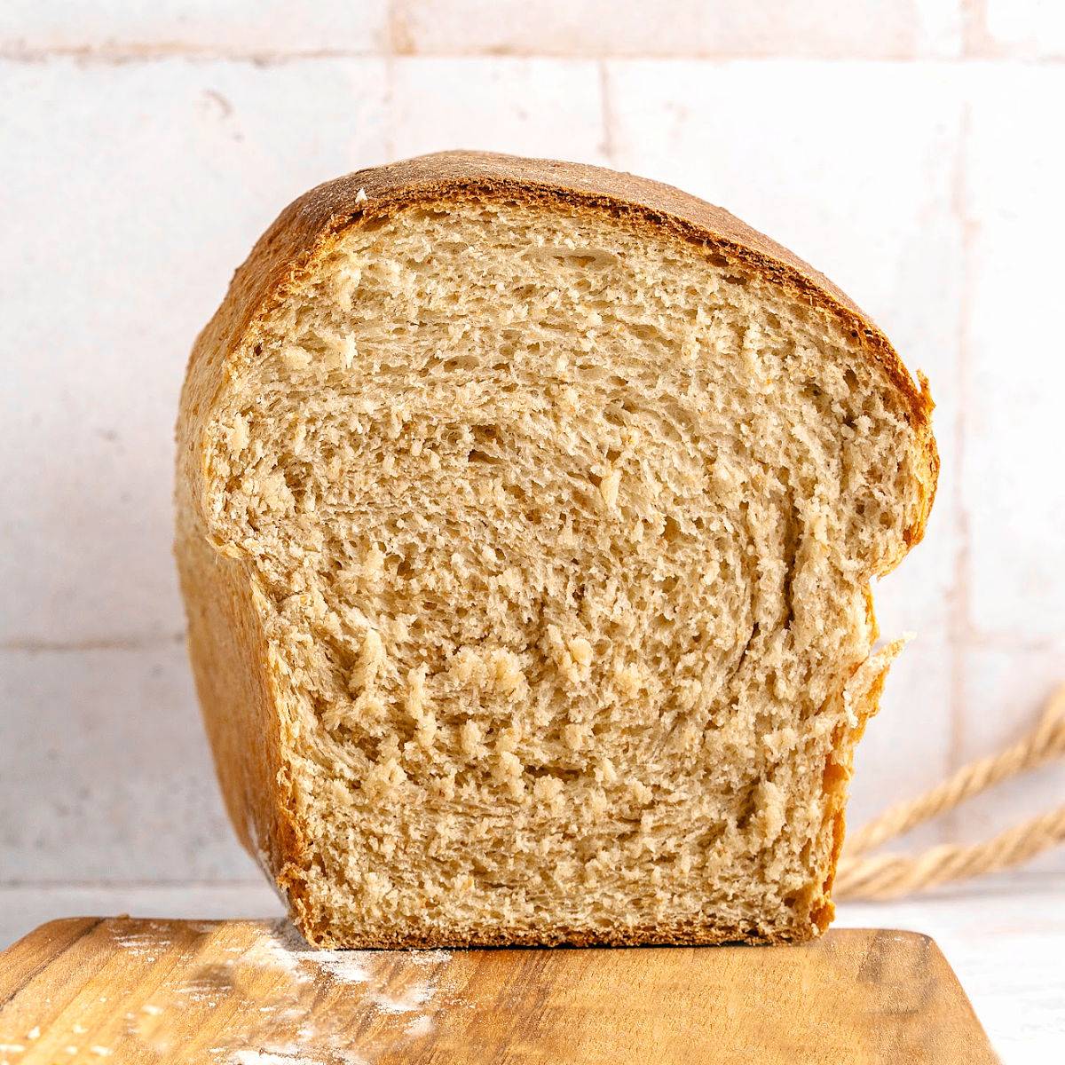 Halved whole wheat sandwich bread on a white background. 