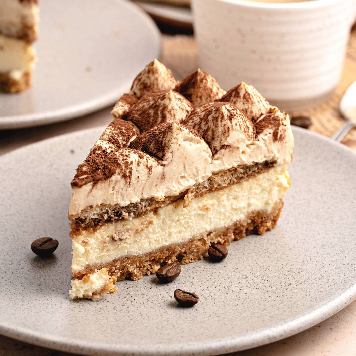 Slice of tiramisu cheesecake on a white plate.