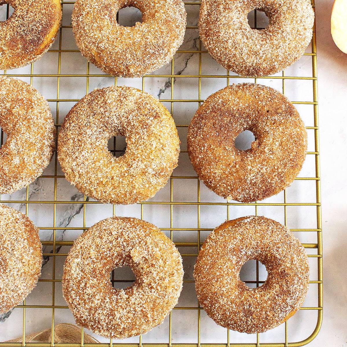 Wire rack with cinnamon sugar cider donuts.