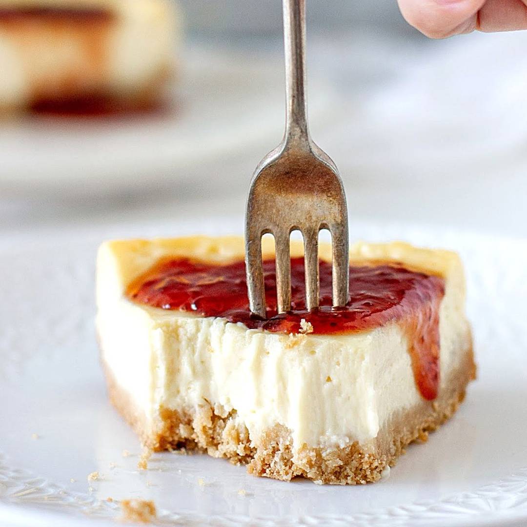 Forking a slice of jam-topped cheesecake. 