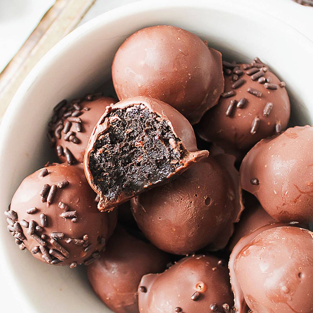 Chocolate covered Oreo balls in a white bowl. 