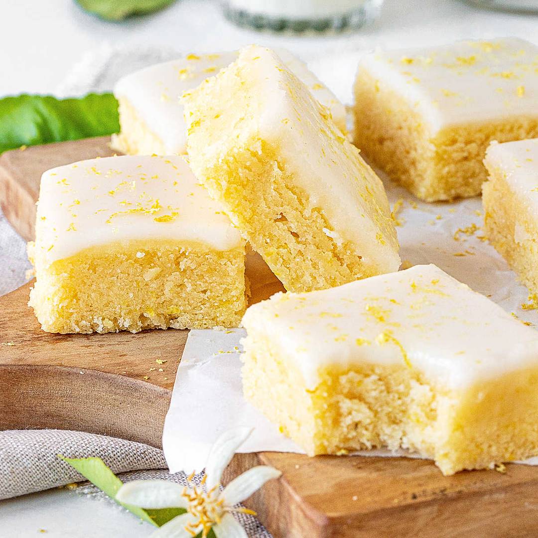 Wooden board with glazed lemon blondies.