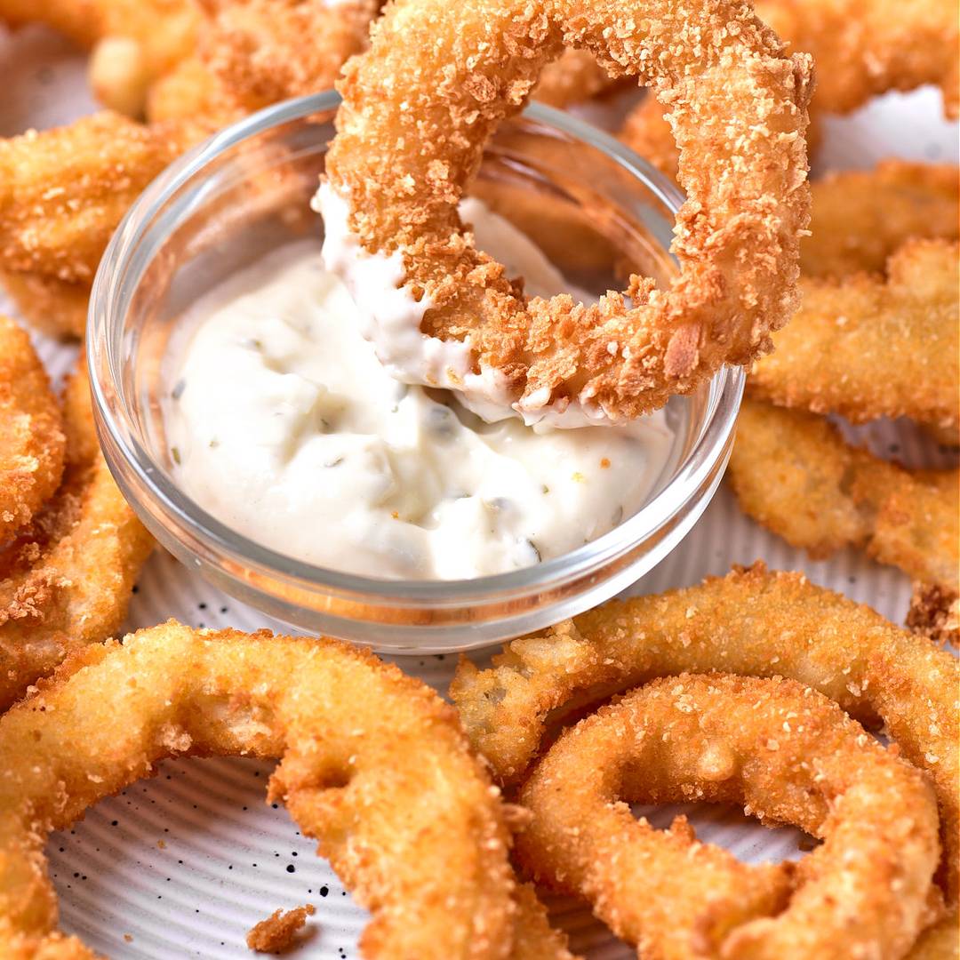 Crisp onion rings. Glass bowl with sauce.