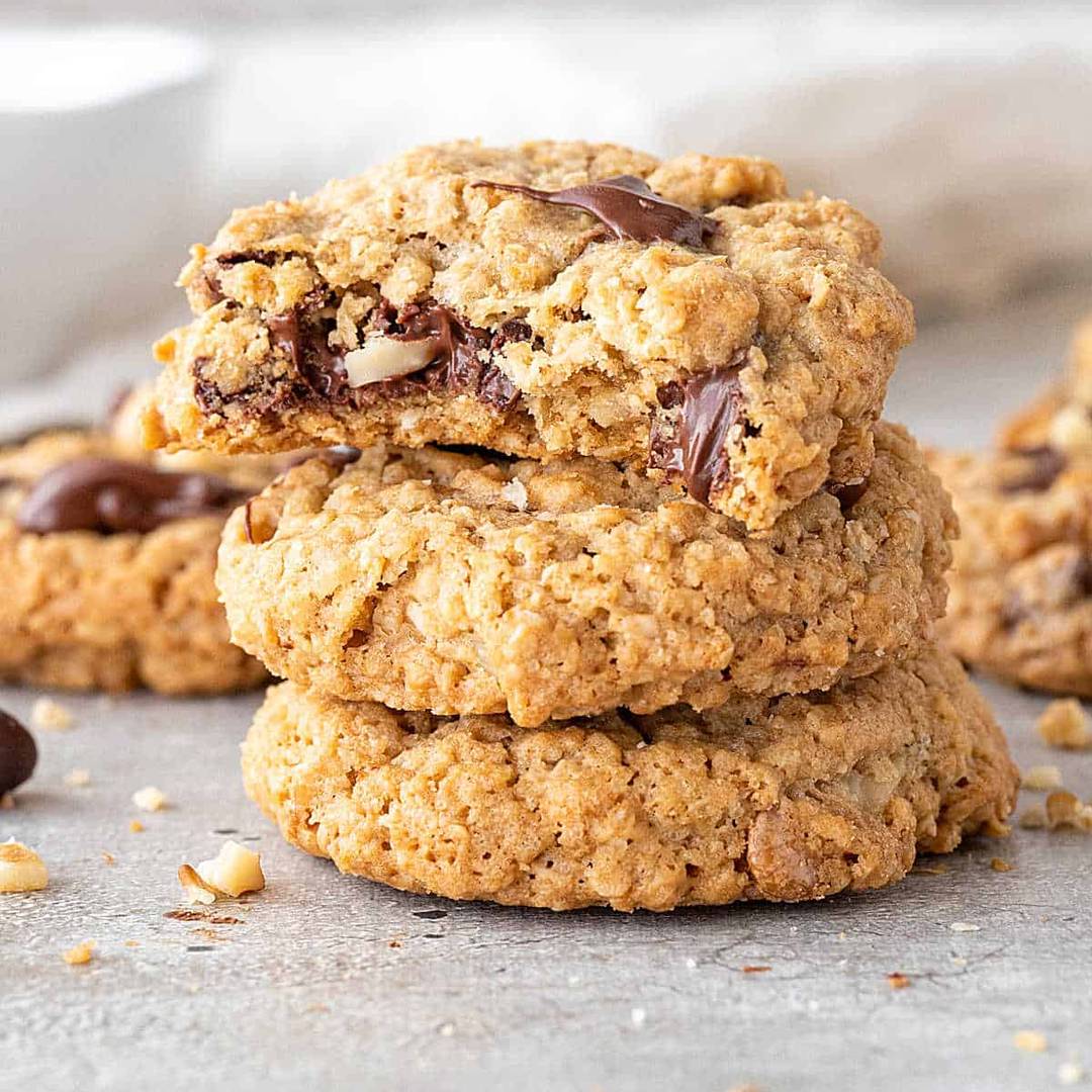 Stack of oatmeal chip cookies. Top one is bitten.