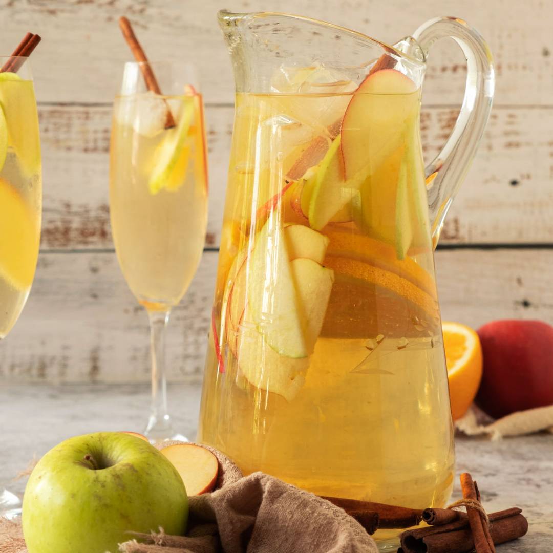 Pitcher and stem glasses of apple cider sangria. 