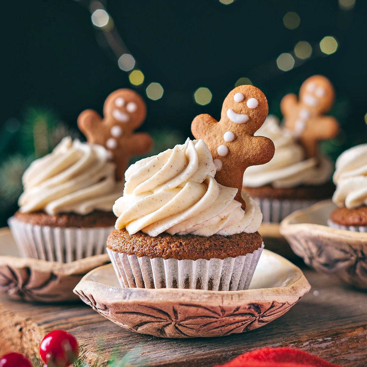 Frosted cupcakes with gingerbread cookies.
