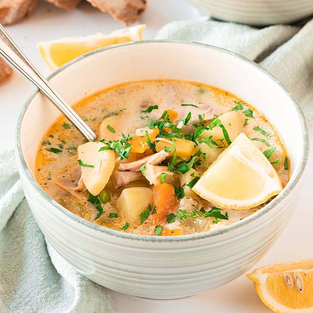 White bowl of turkey veggie soup.