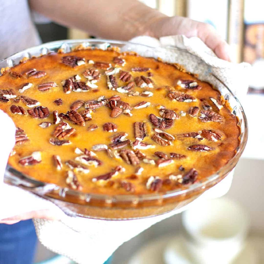 Glass pie pan with pecan topped sweet potato pie.