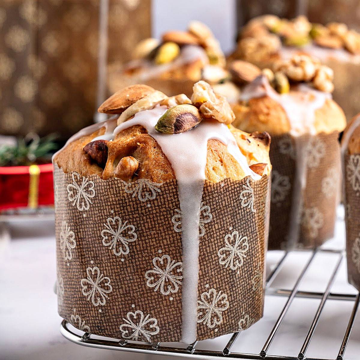 Several glazed panettone breads in large paper liners.