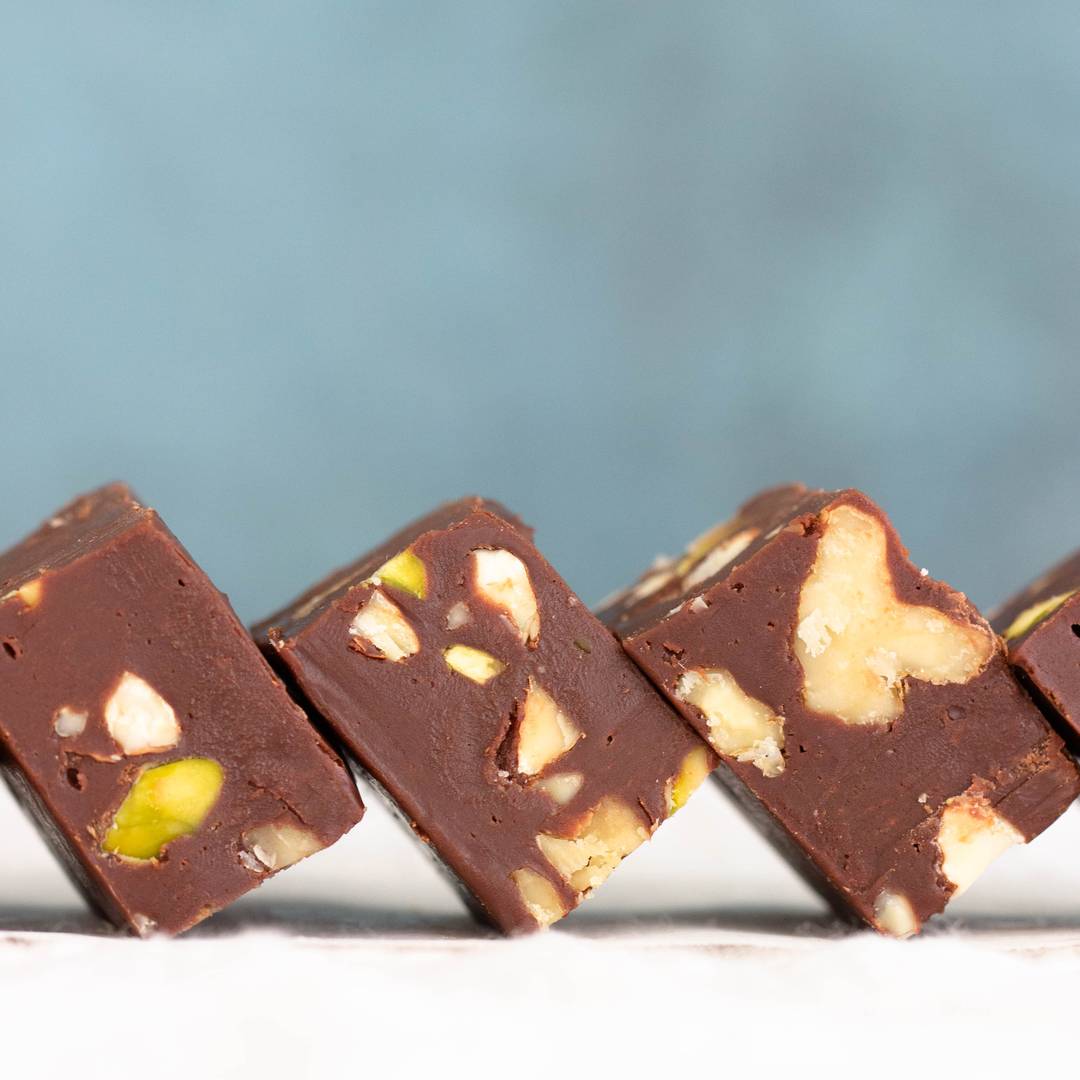 Leaning squares of chocolate nut fudge.