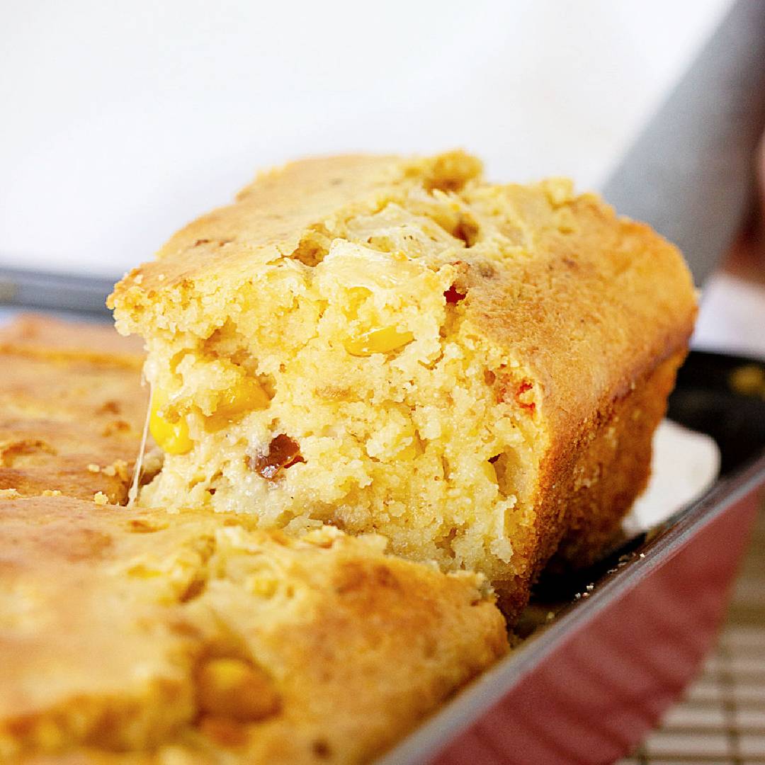 Serving of cornbread lifted from the pan.