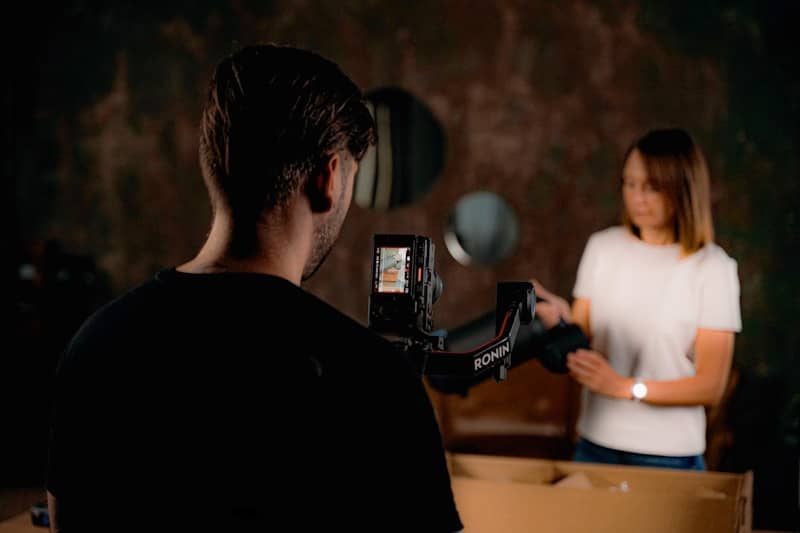 Filming a woman with a camera and gimbal rig.