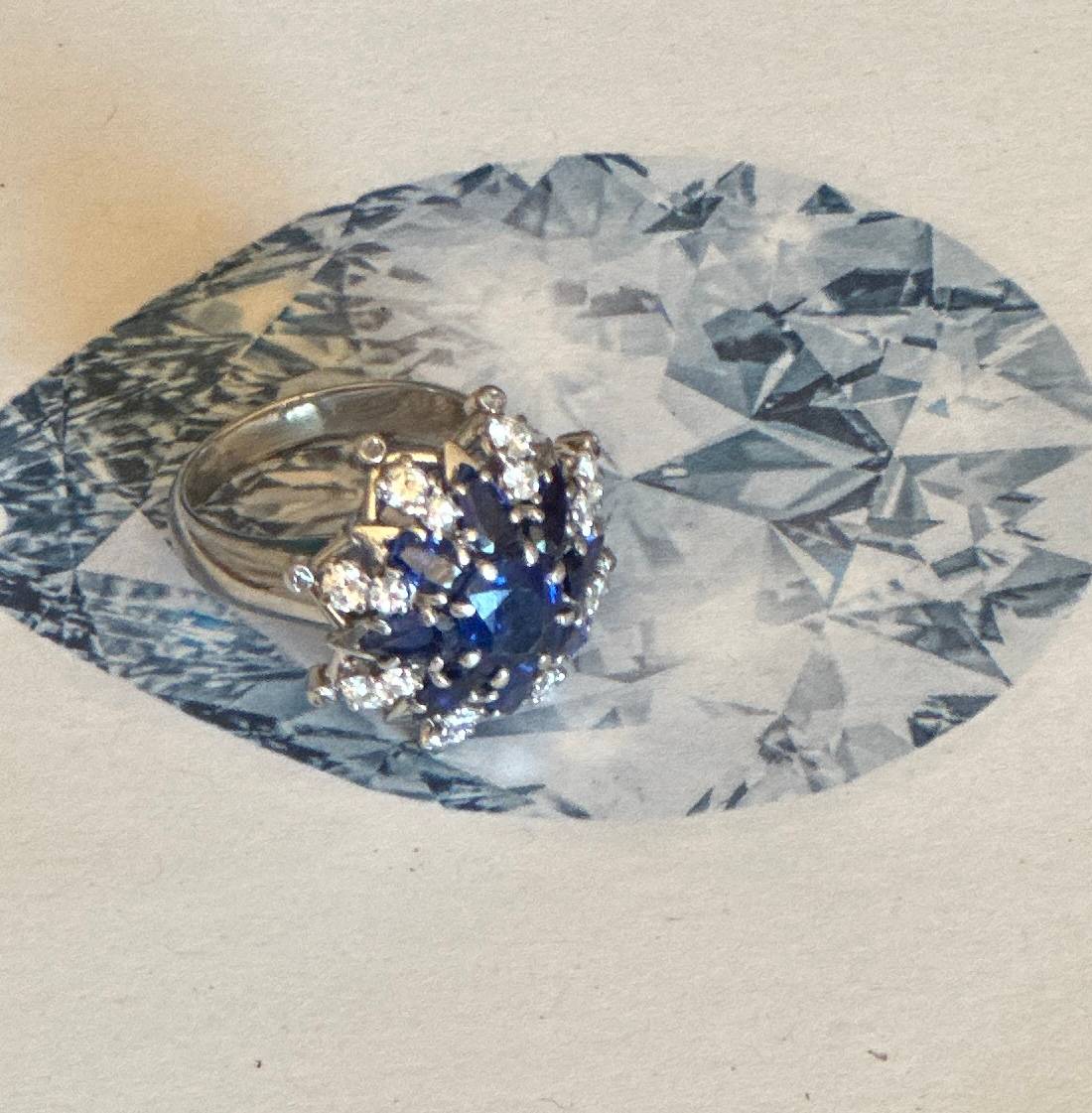 A close of of a white gold cocktail ring with sapphires and diamonds