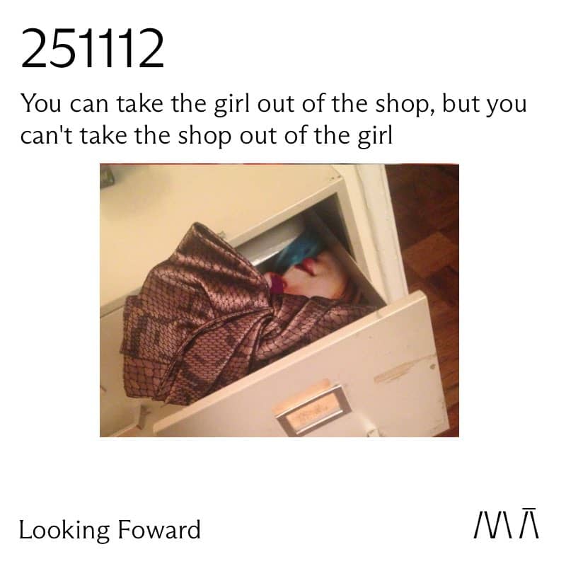 A picture of a clutch bag in a drawer in front of a portrait photograph