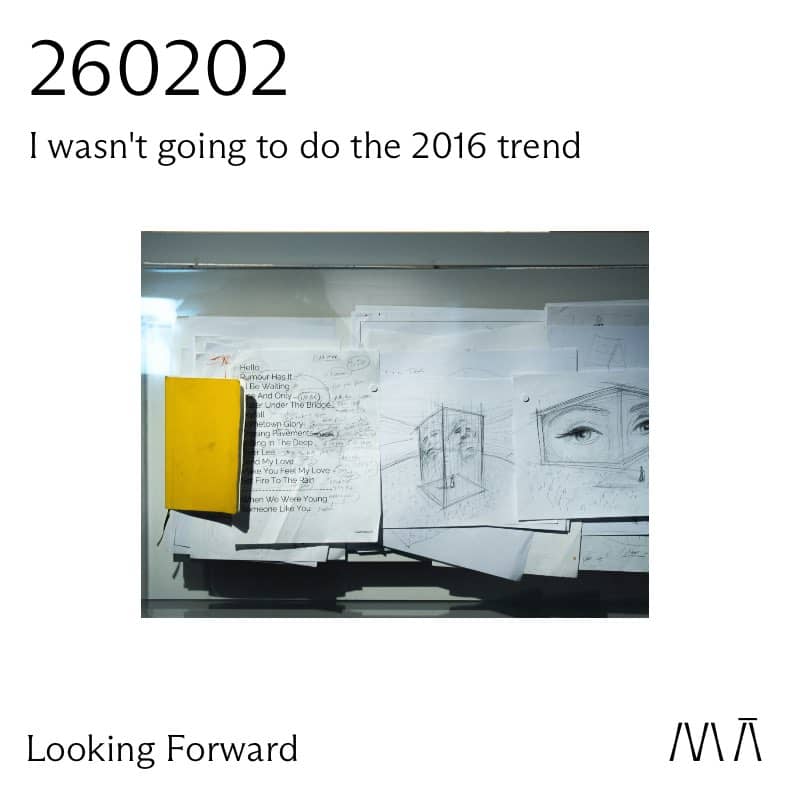 A yellow notebook next to written text and drawings 