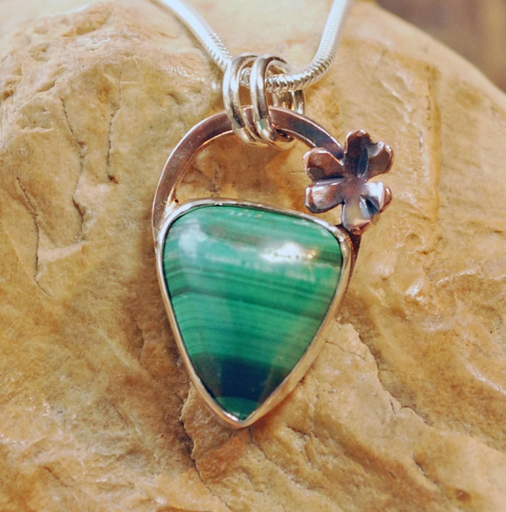 Malachite silver pendant with copper shamrock above stone.