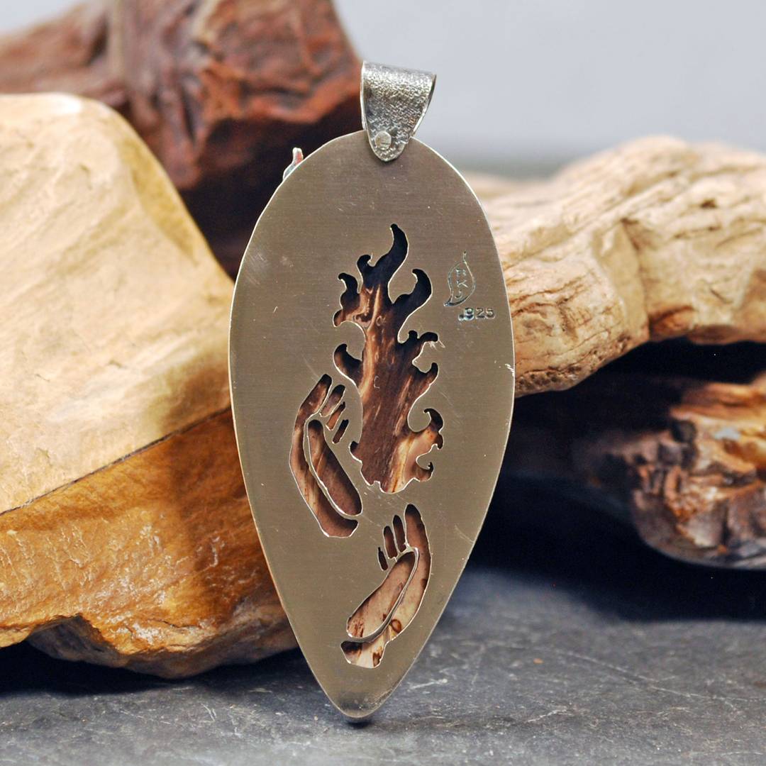 Back of Palm Root pendant, with cut out hands and flame behind the stone