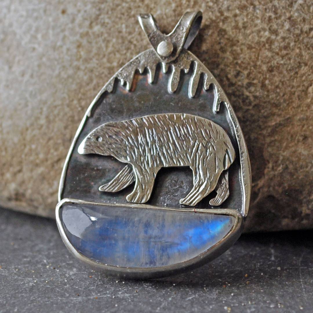Silver pendant with moonstone and silver polar bear above stone