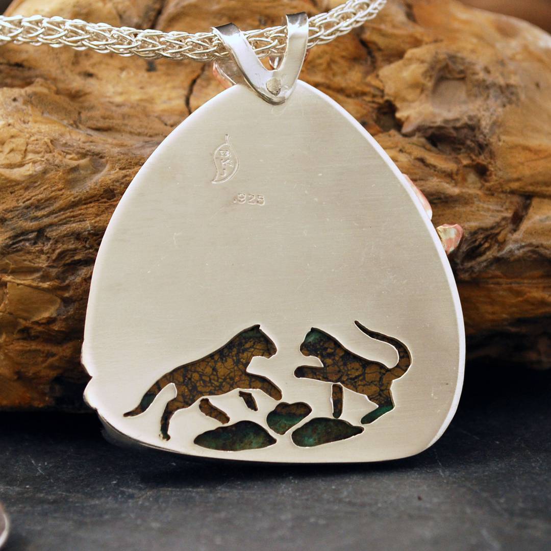 Back of cougar pendant with two cut-out cougar cubs