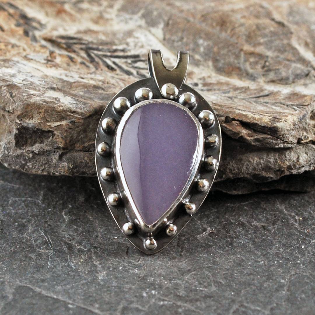 Silver pendant with purple fluorite cabochon, silver balls framing the stone