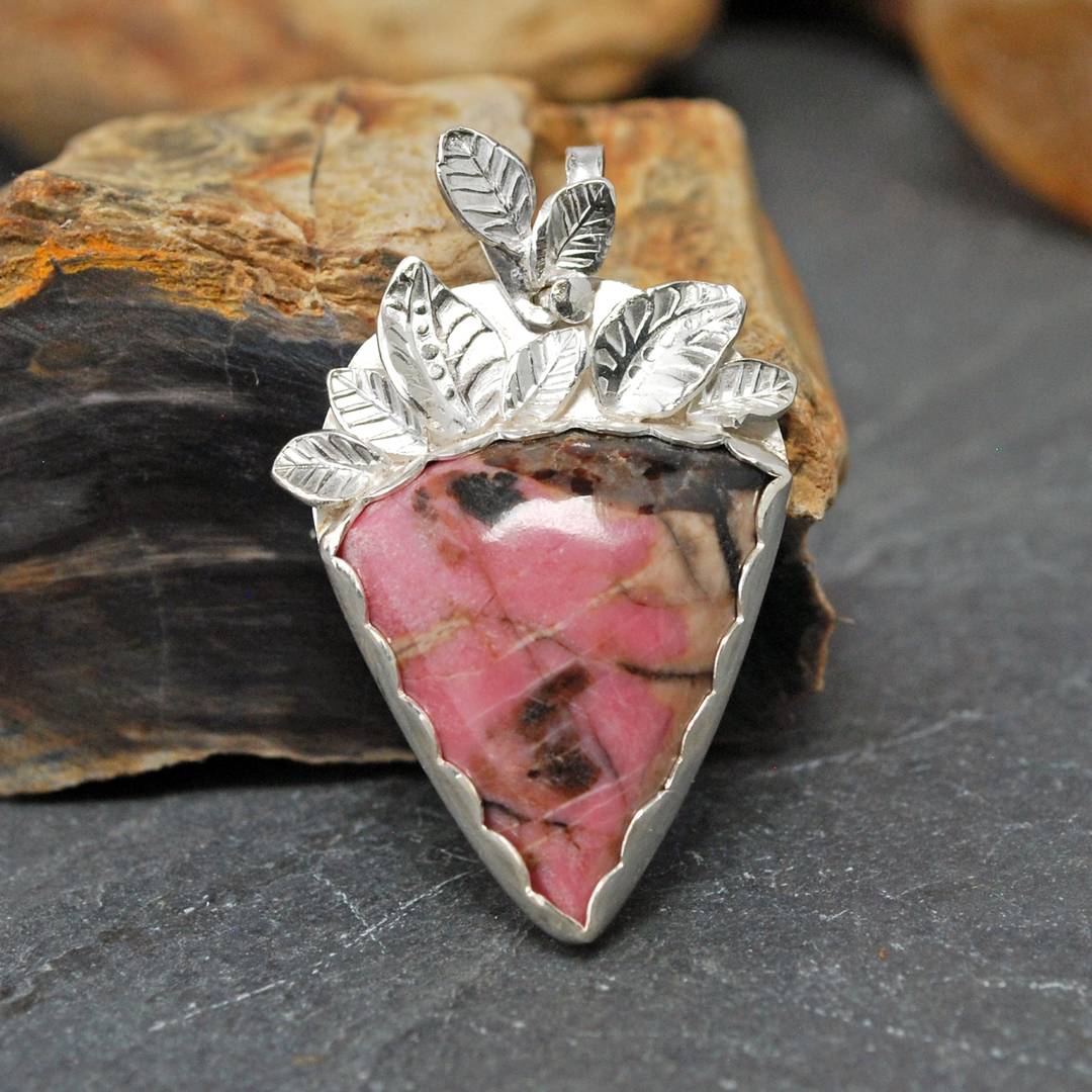 Silver pendant with pink rhodonite stone and fine silver stamped leaves above stone