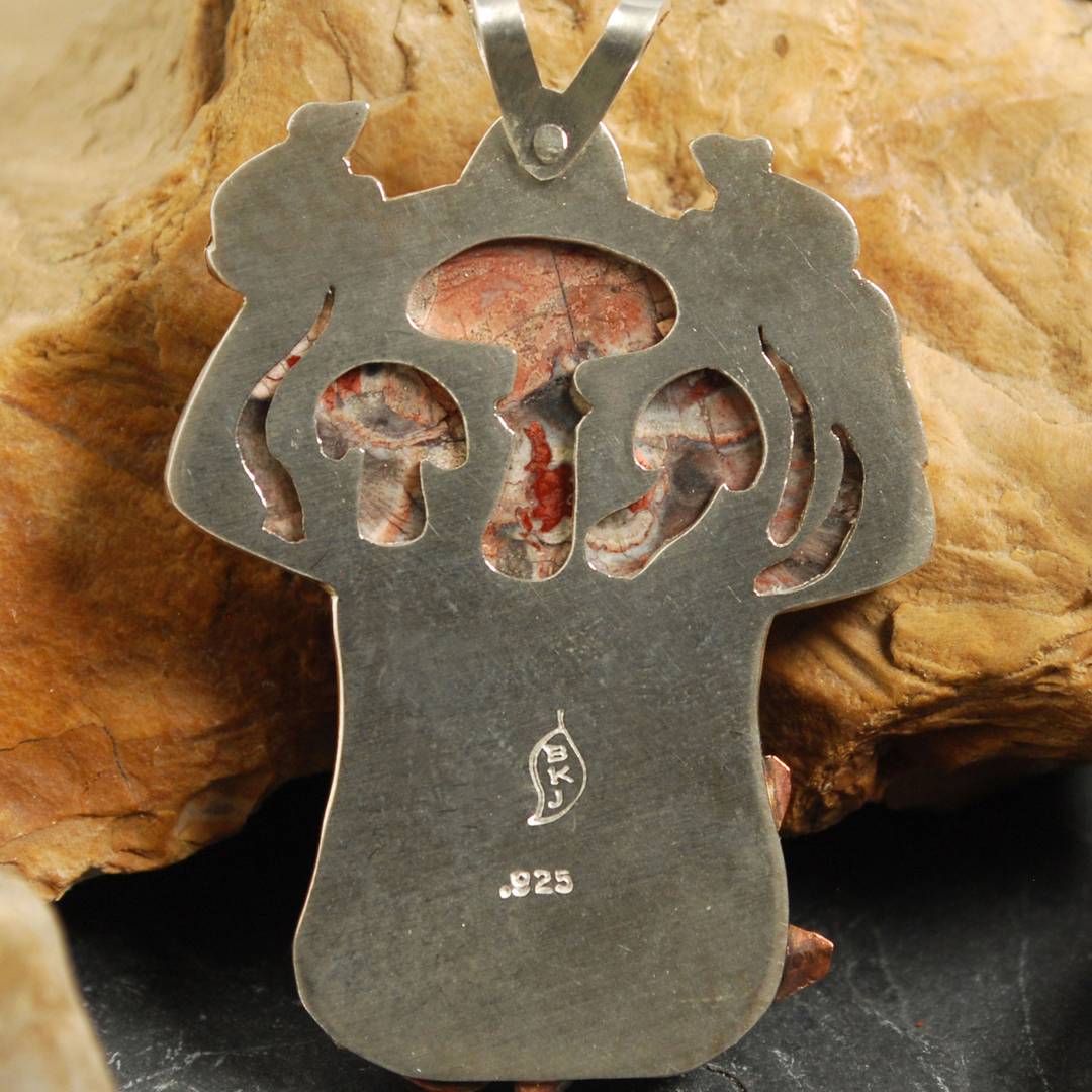 Back of pendant showing mushrooms cut out