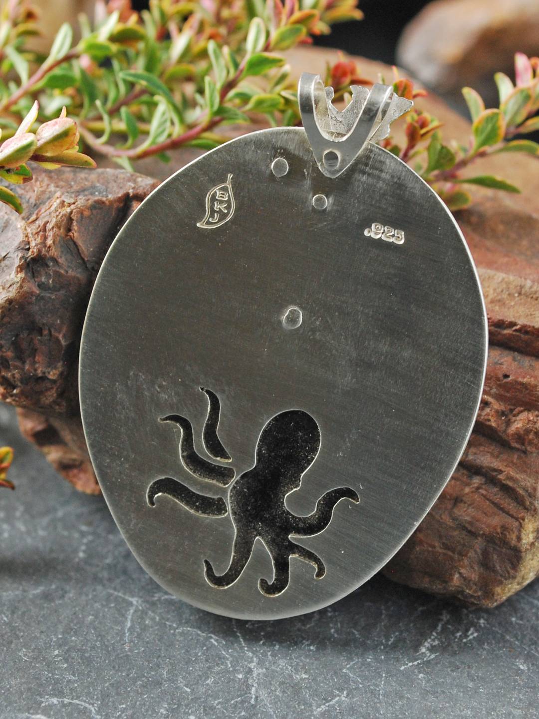 Back of coral garden pendant with cut out octopus behind stone