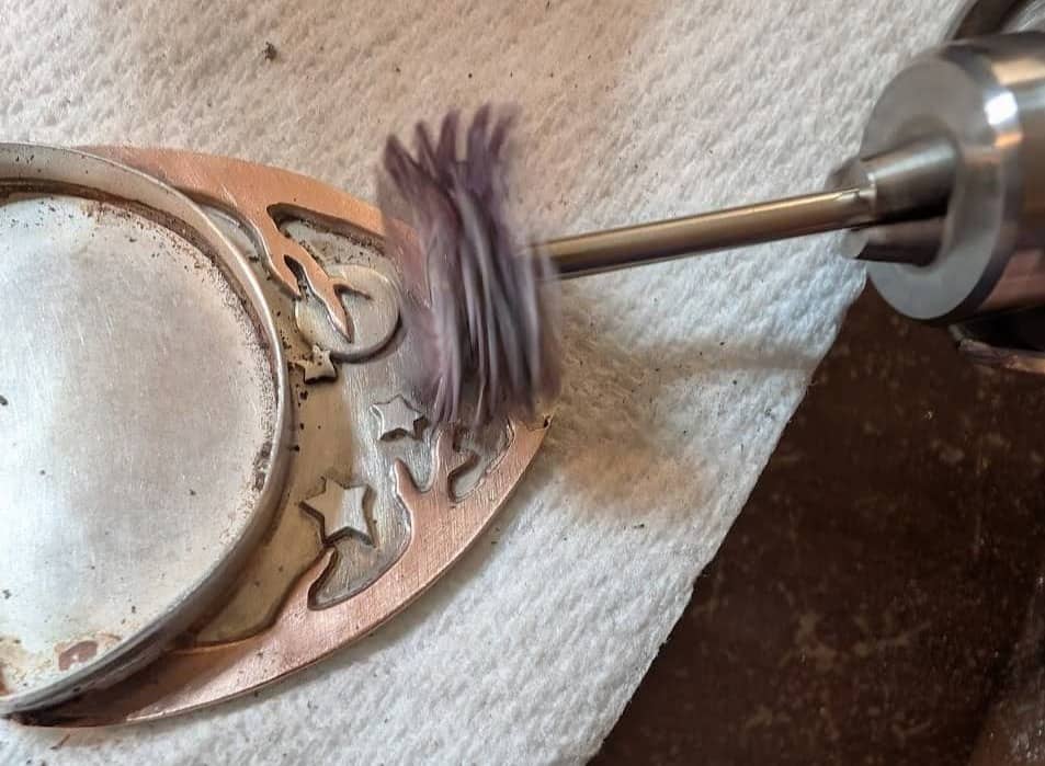 Silicon radial bristle wheel being used to clean a pendant after soldering