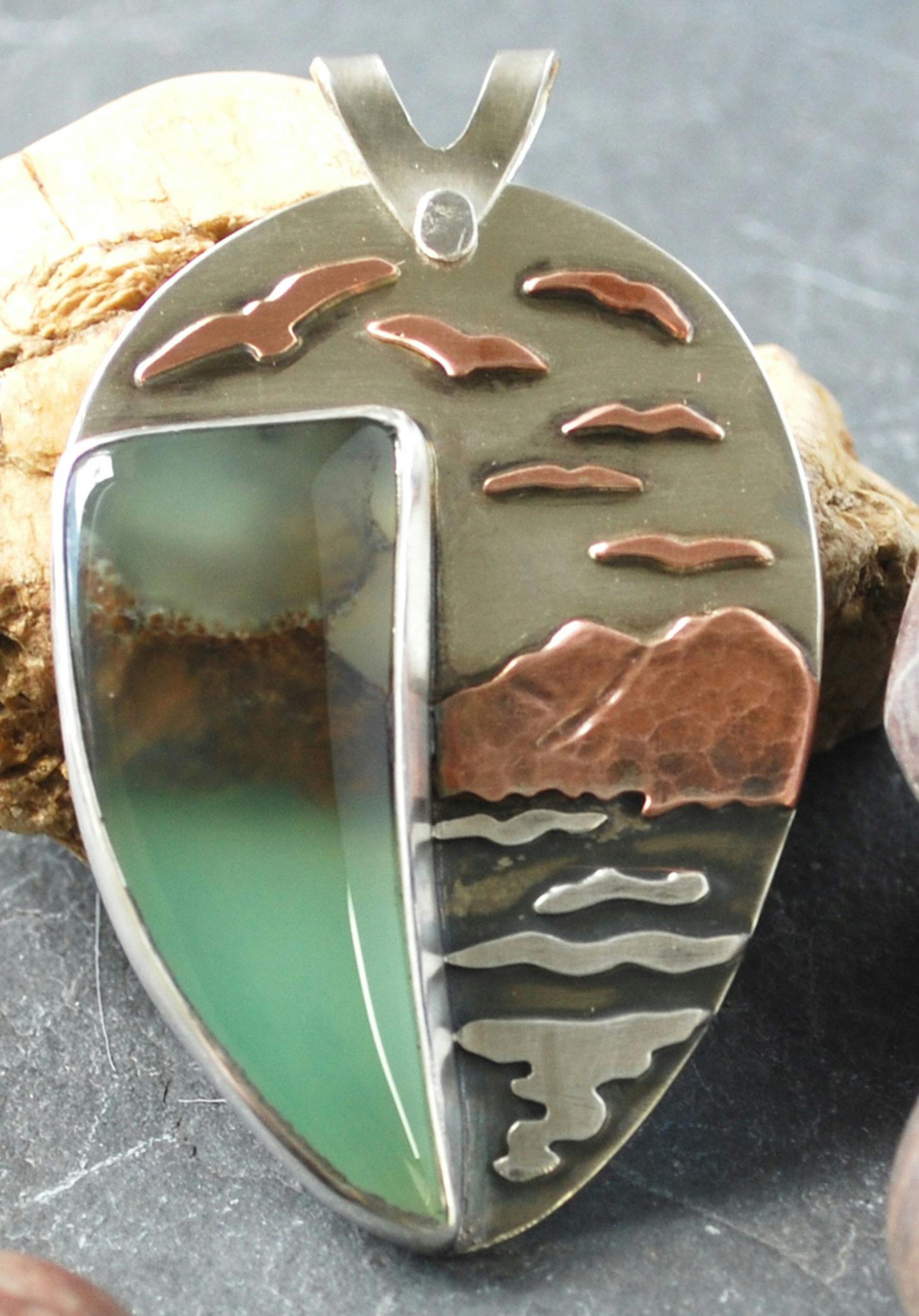 Pendant with curved chrysoprase cabochon, design of mountains, water, birds next to stone