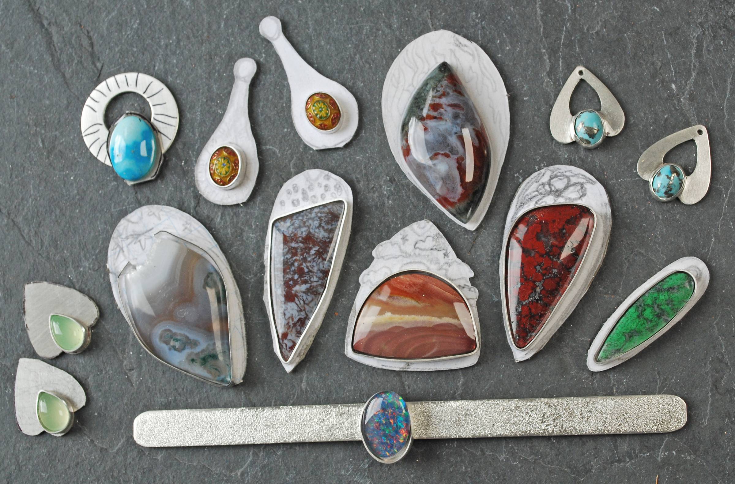 Group of jewelry projects in process: earrings, pendants, cuff