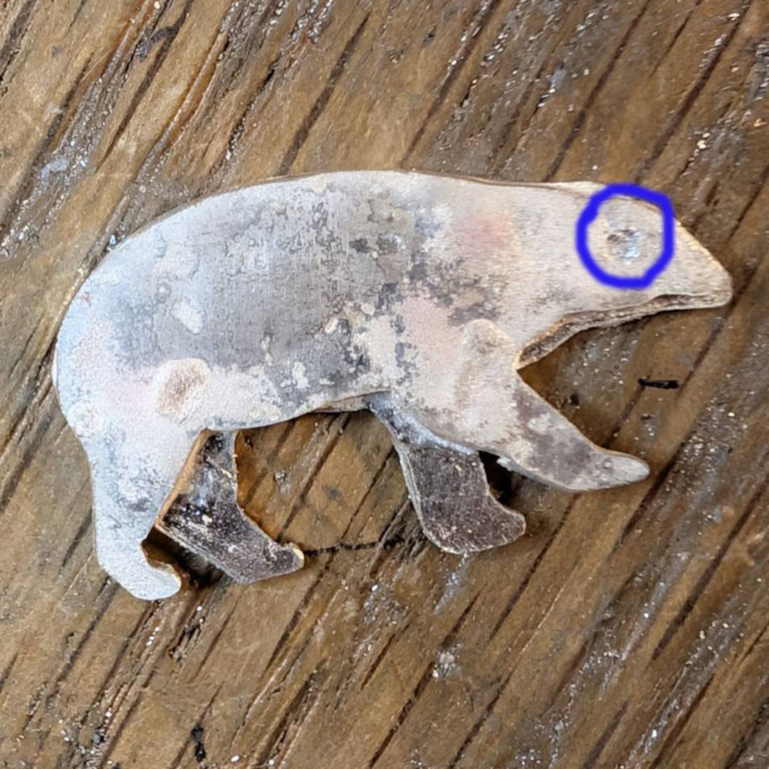 A rough cut out of a polar bear, with the drill hole cut out