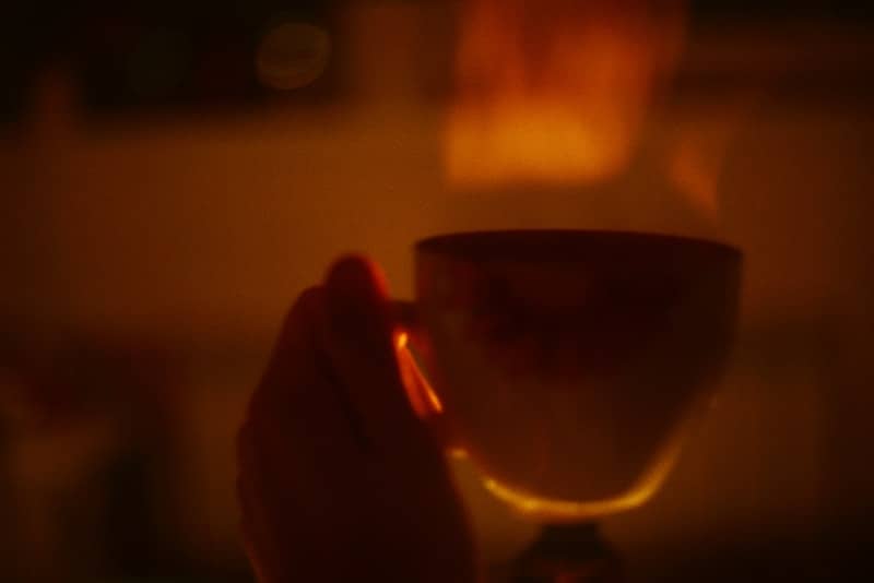 Hand holding a steaming cup of hot beverage