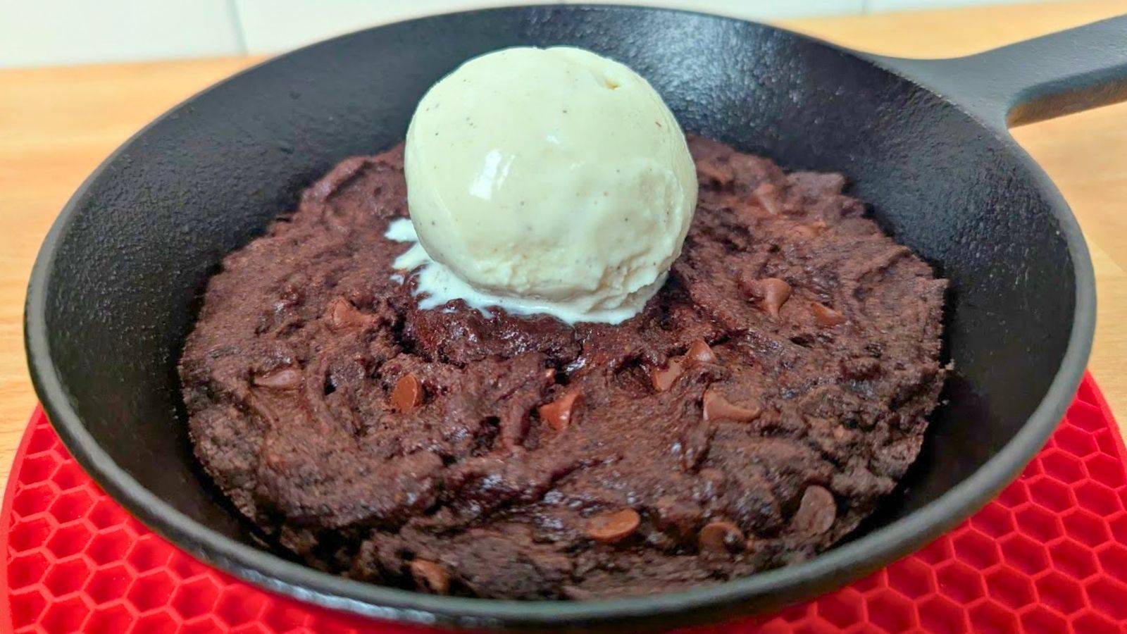 A skillet brownie with a scoop of vanilla ice cream on top.